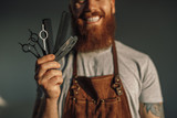 Cheerful barber showing set of tools