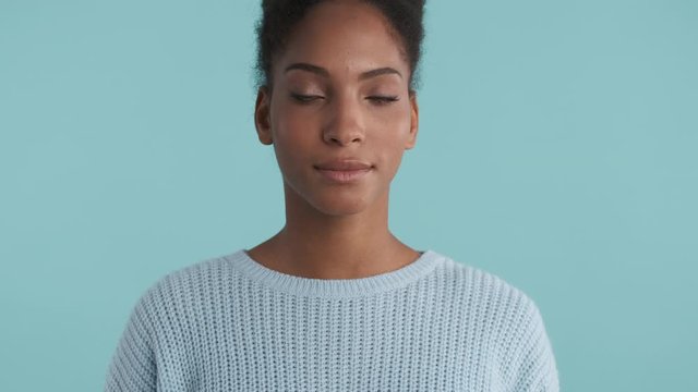 Portrait of beautiful african american girl confidently looking in camera over blue background