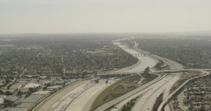 Aerial shot, day, high altitude view of highways and manmade river, california neighborhood, drone