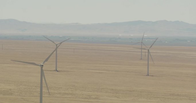 Aerial shot, day, zoom on wind farm in desert balley, drone