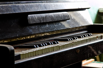 Old broken piano in ruined abandoned building, close up