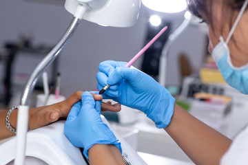 The application of gel polish on the nail top view.The concept of nail service