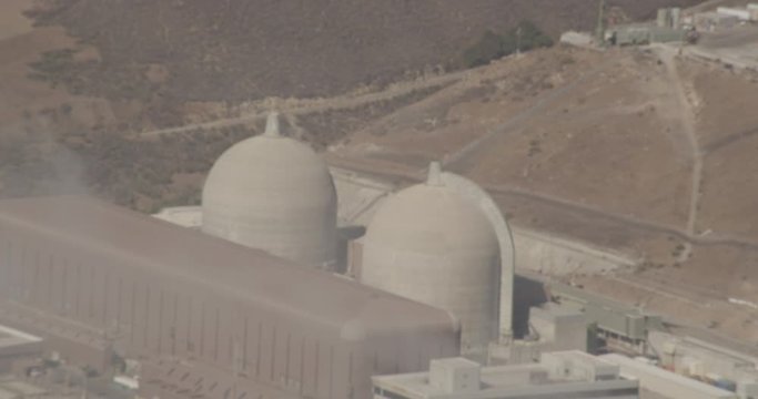 Aerial shot, day, extreme zoom on industrial factory on coast, drone