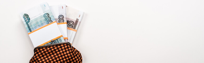 panoramic shot of russian money in plaid vintage wallet on white