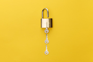 top view of padlock with keys on yellow background