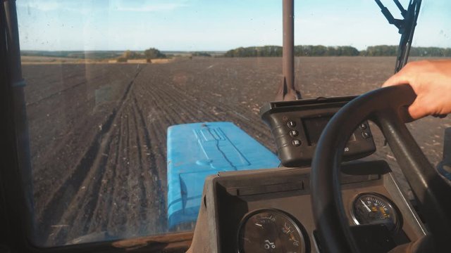 Farmer driving tractor in cultivating field. Agricultural works at tractor.