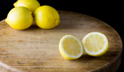 Fototapeta na wymiar Fresh lemons on wooden table with black background