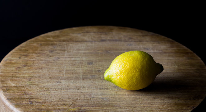 Fresh lemons on wooden table with black background