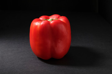 Fresh red bell pepper isolated on dark background