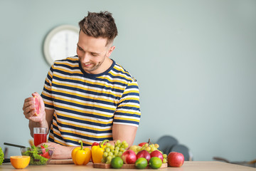 Fototapeta premium Handsome man with healthy products making juice in kitchen. Weight loss concept