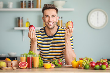 Handsome man with healthy products in kitchen. Weight loss concept