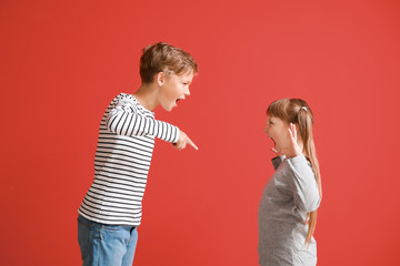 Portrait of quarreling little children on color background