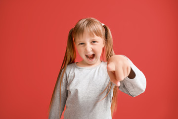 Portrait of angry little girl on color background