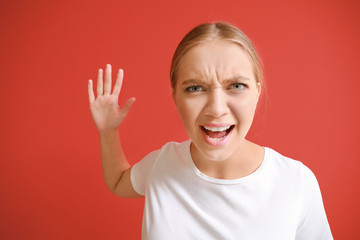 Portrait of angry woman on color background