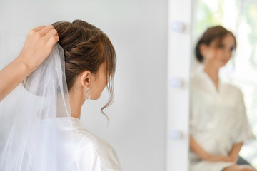 Professional hairdresser working with young bride at home