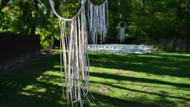 Wedding ceremony decoration on wind. Wind blows colorful ribbons in spring sunlight