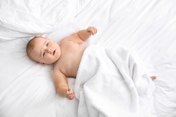 Cute little baby after bathing lying on bed