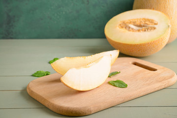 Board with slices of ripe melon on table