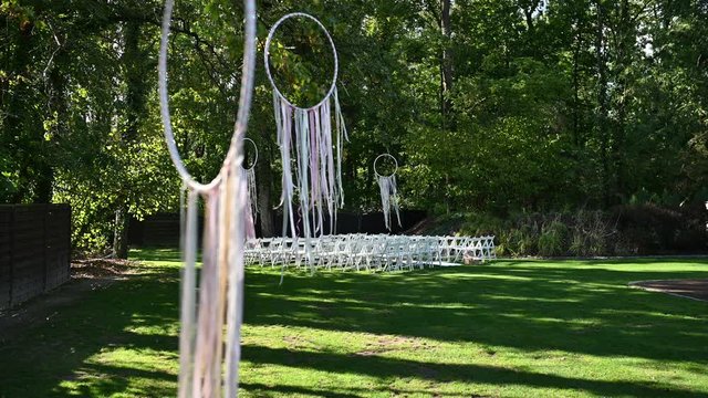Wedding ceremony decoration on wind. Wind blows colorful ribbons in spring sunlight