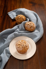 Oatmeal Raisin Muffins on a White Plate with Blue Cloth on a Wood Table
