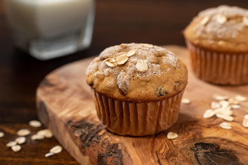 Oatmeal Raisin Muffin on Wooden Table with Glass of Milk
