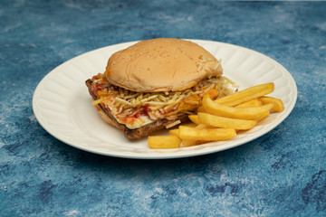 Hamburger with meat, tomato, lettuce and french fries.
