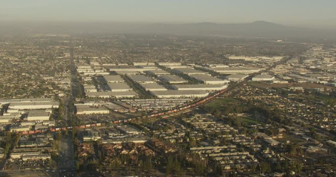 Aerial shot, day, focus on trainyard in la neighborhood, drone