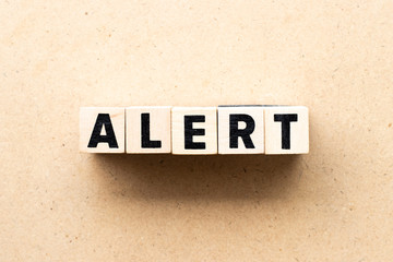 Letter block in word alert on wood background