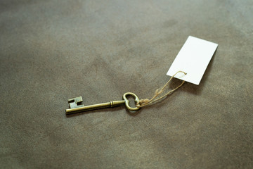 Old vintage brass key with white tag
