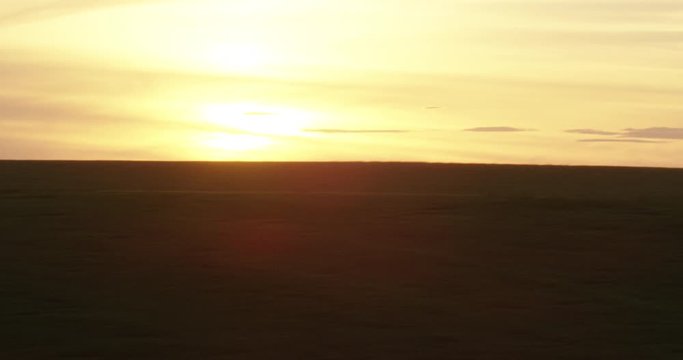 Hazy yellow sunset over green hills, drone, helicopter aerial 