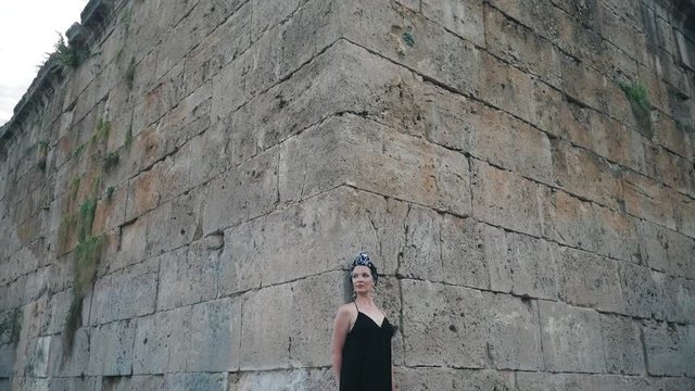 Beautiful young attractive Muslim woman in long black dress standing on the corner of Hidirlik tower, historical place