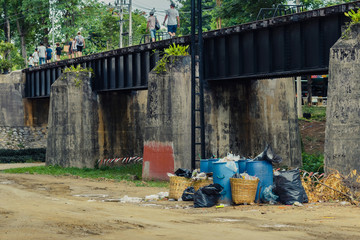 Fototapeta na wymiar The area that dumped garbage under The Bridge of the River Kwai in Kanchanaburi, Thailand. pollution garbage waste, lots of junk dump, plastic garbage waste is environment pollution.