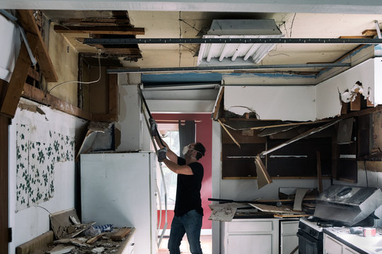 Kitchen: Man Using Crowbar To Take Down Cabinetry