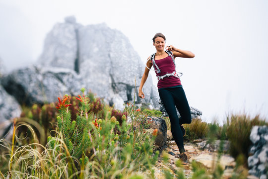 Female trail runner in misty mountains