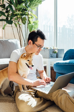 Man using laptop with dog