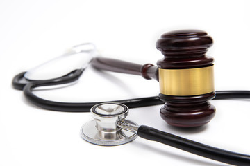 A wooden judge gavel and stethoscope isolated on white background. Medical dispute concept.