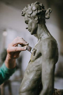 Hands of sculptor mold clay statue