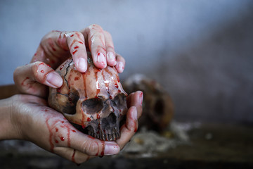 Horror skull with blood on hand for Halloween concept 