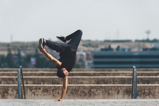 Young hispanic latin break dancer performing a dance pose in urban scenery
