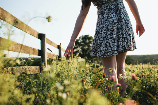 Woman walking through grassy field