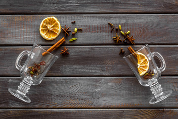 New Year beverage. Ingredients for mulled wine in glasses on dark wooden background top view copy...