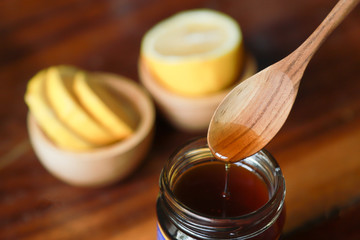 spoon picking honey from bottle 