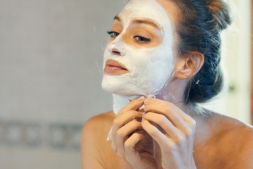 Relaxing woman removing cleansing mask