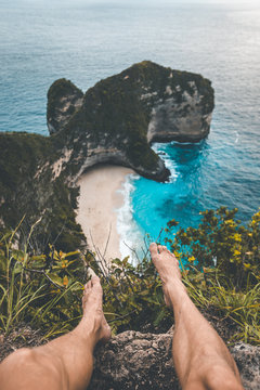 traveller sitting on the edge overlooking kelingking beach