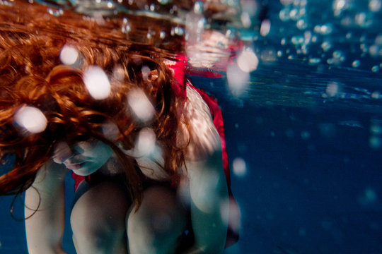 beautiful woman with long red hair underwater