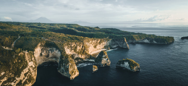 panorama shot of indonesian coastline at sunrise with mount agung in the back