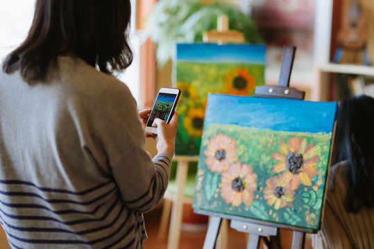 Young woman taking pictures for her art work