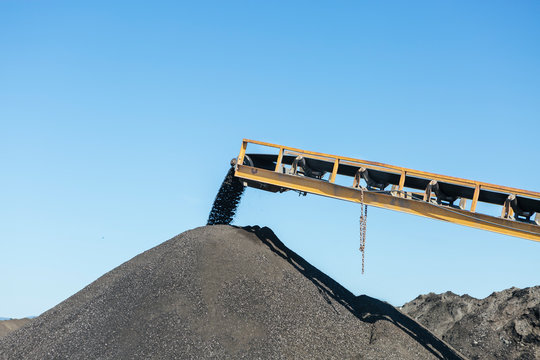 Conveyor belt pouring gravel on a heap