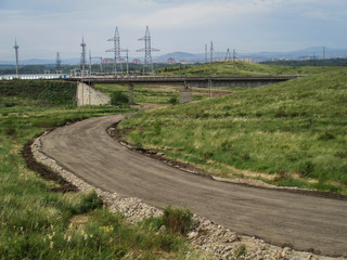 Asphalt road in the steppe. Outskirts of Ust-Kamenogorsk (Kazakhstan). Green grass. Central Asia