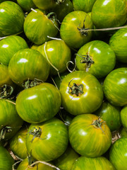 Green zebra tomatoes on display in a store or market.